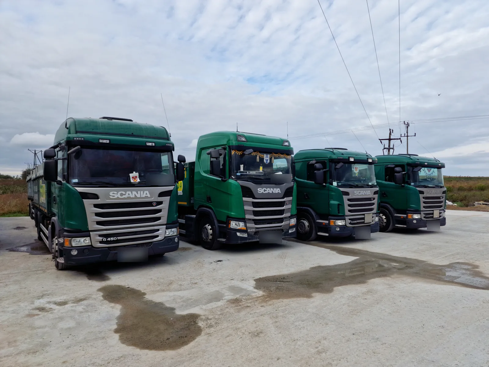 Cztery firmowe ciężarówki Scania ustawione obok siebie